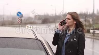 一个女孩在一条空的雨<strong>天路</strong>上用电话寻求帮助，并停止过车。